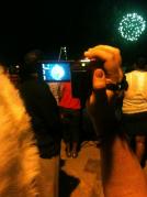 A photographer shoots the fireworks at the end of the Boat Parade.
